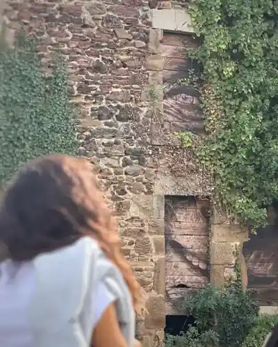 Clarisse devant une œuvre peinte sur de vieilles portes en bois